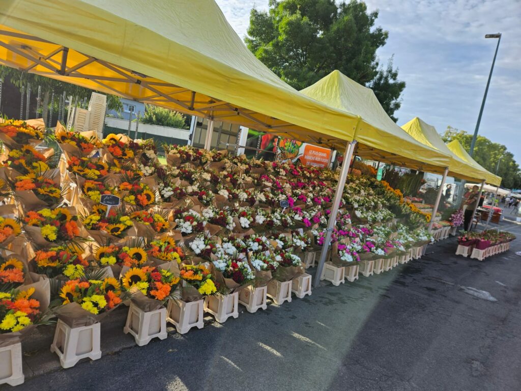 Bouquets alignés sous les chapiteaux du marché
