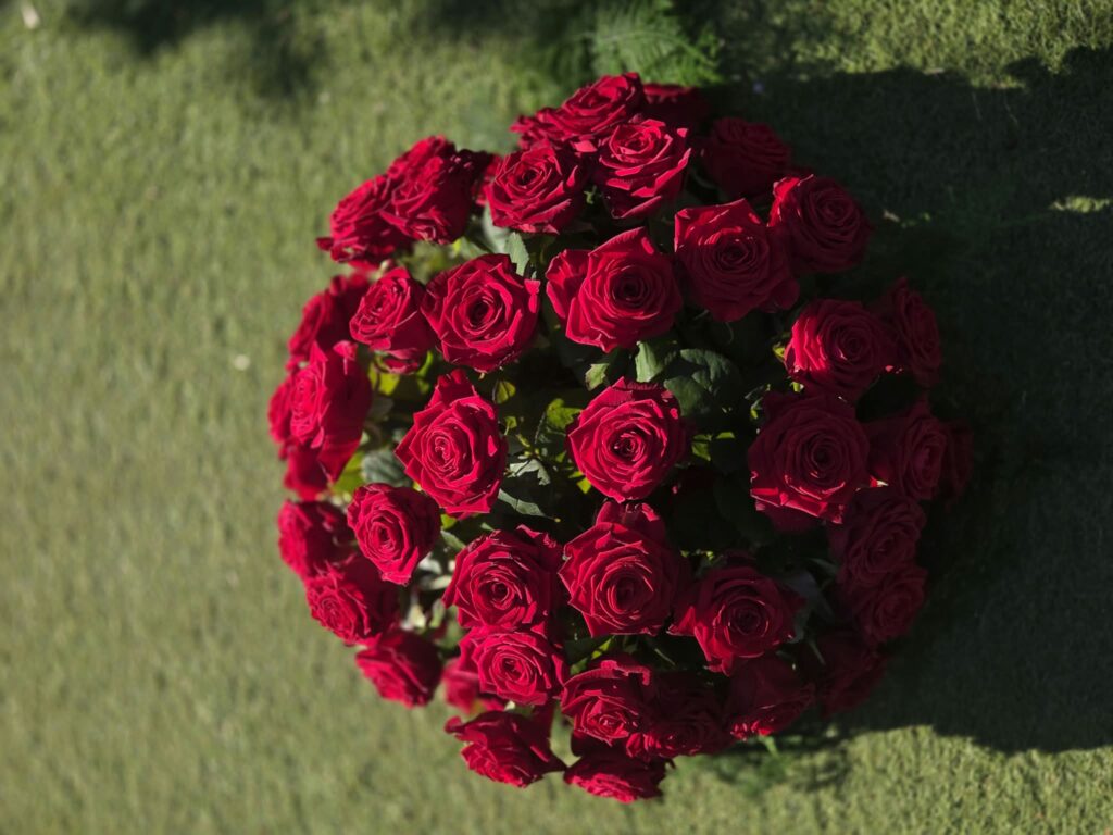 Gros bouquet rond composé uniquement de roses rouges à longues tiges, vu de dessus
